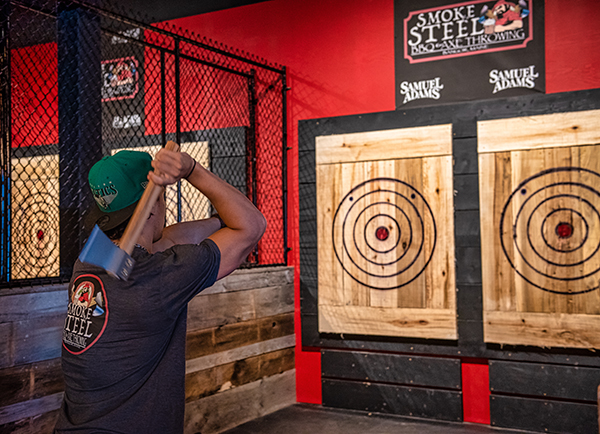 Man throwing an axe at a wooden target