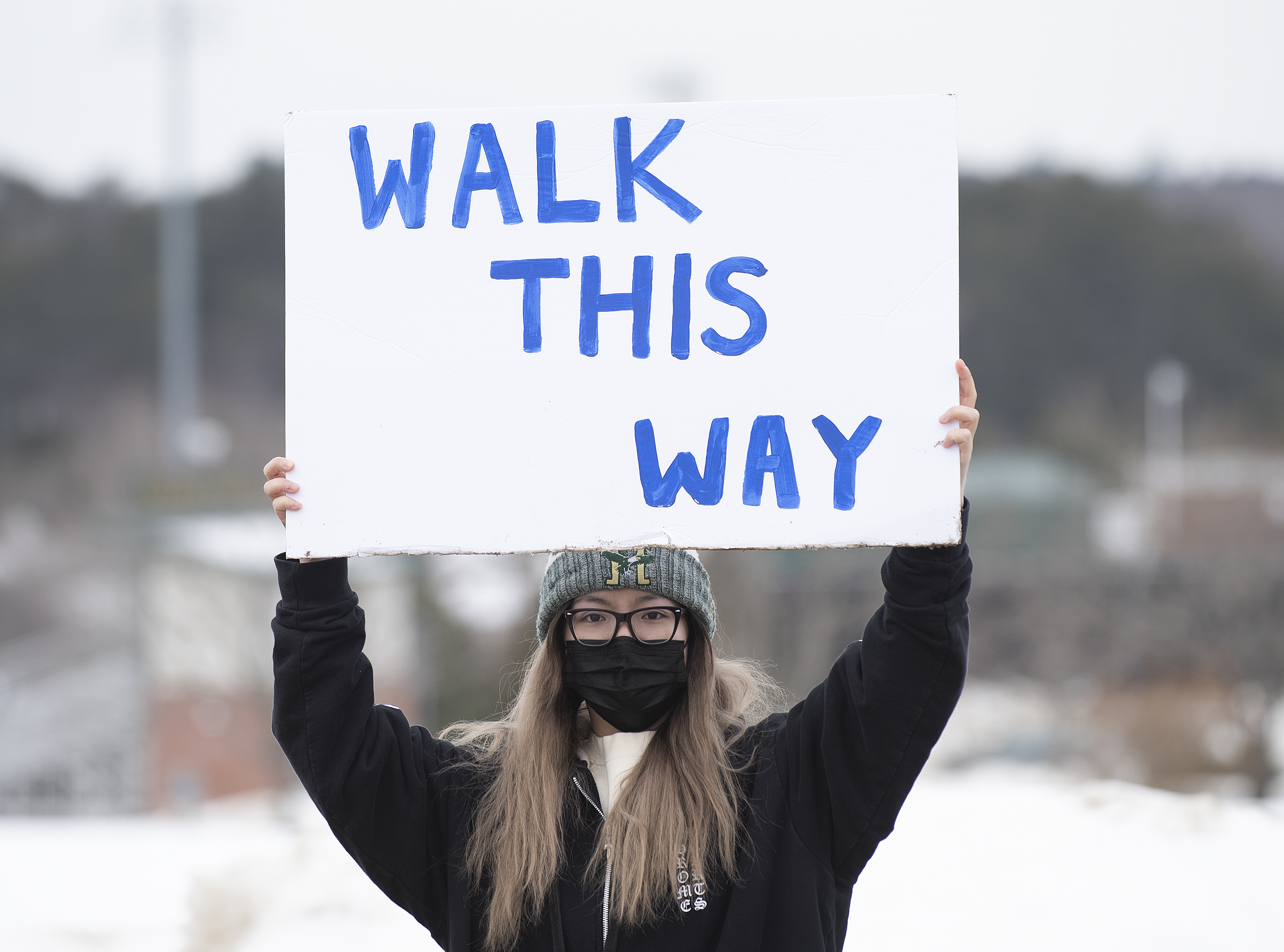girl holding sign that says walk this way