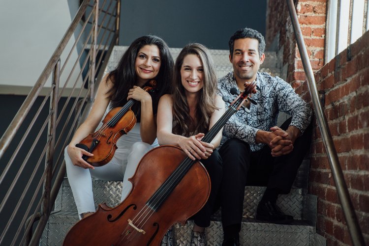 three people sitting on steps while holding instruments