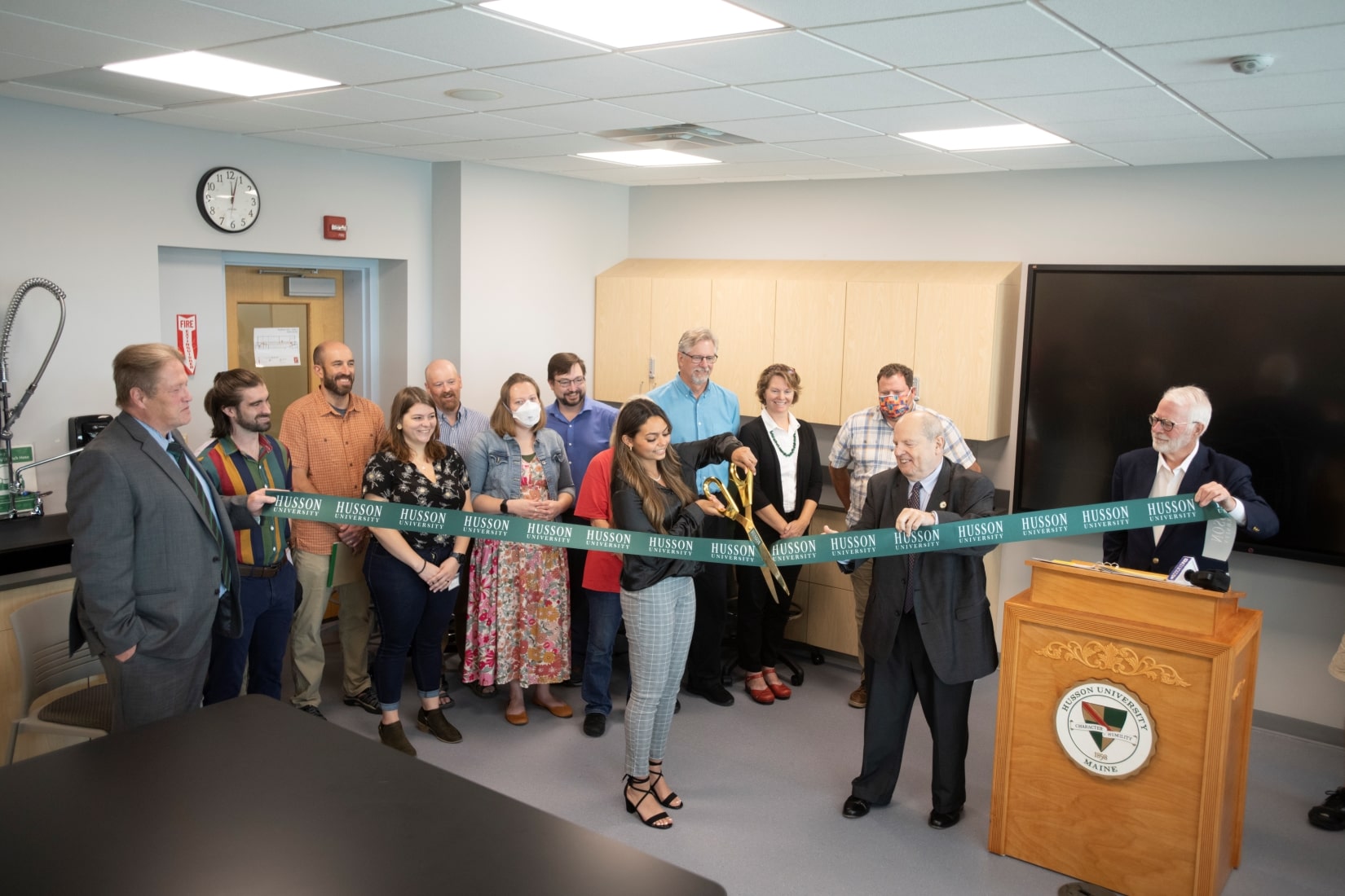 group of people participating in a ribbon cutting ceremony