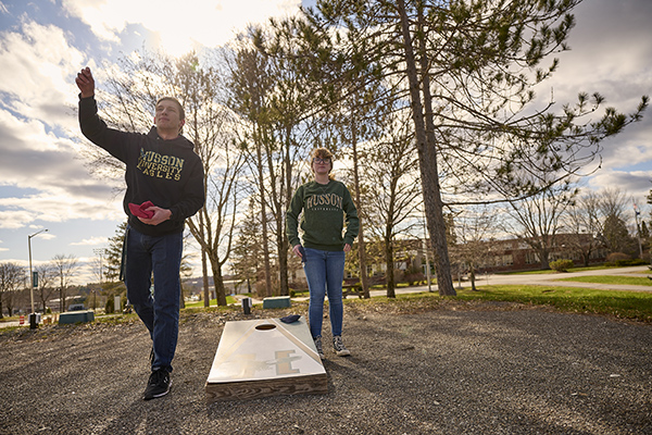 Students play cornhole outside Bell Hall