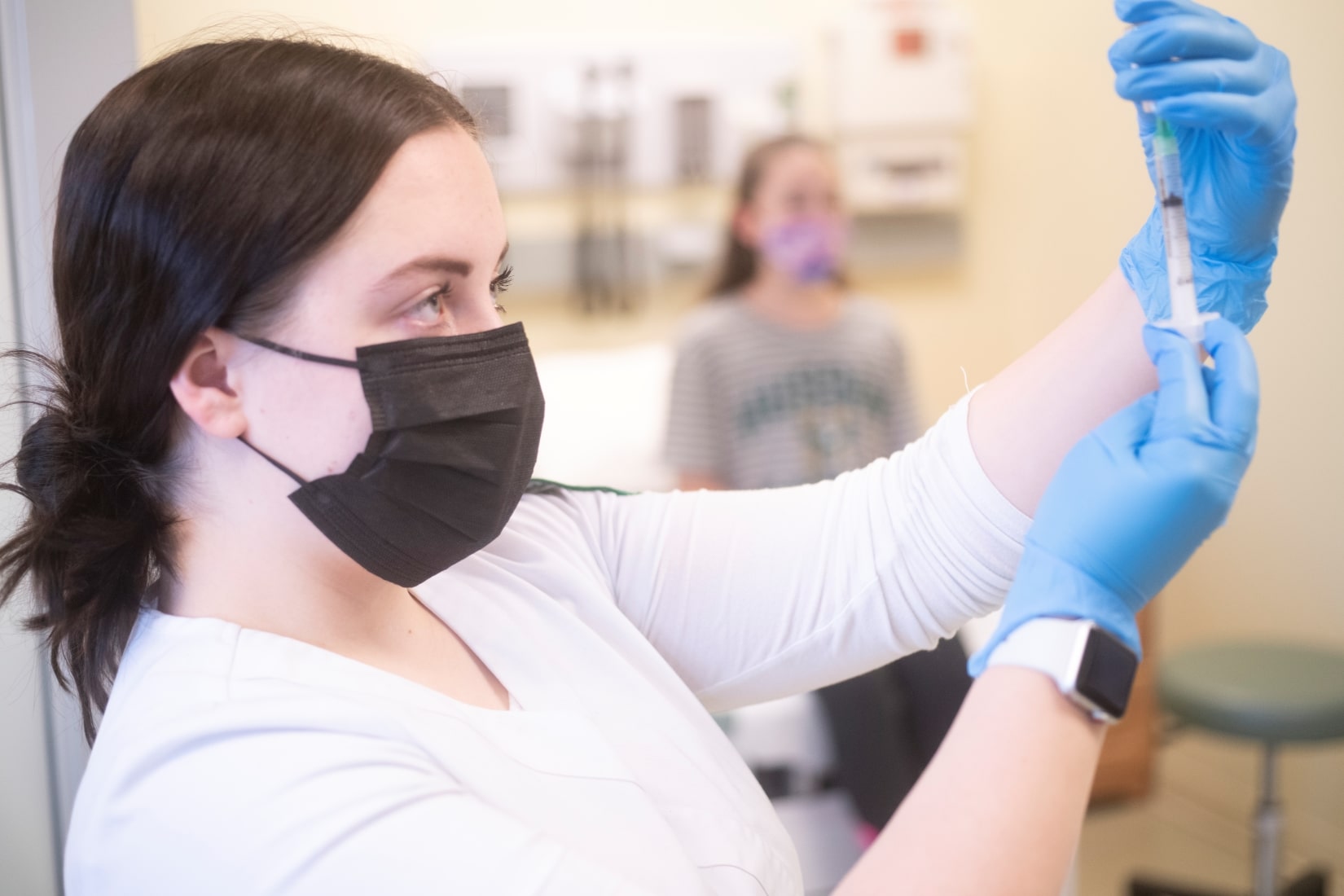 Nurse preparing a vaccination for a child.