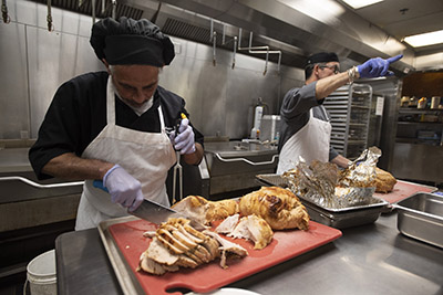 man prepares a turkey for thanksgiving meals