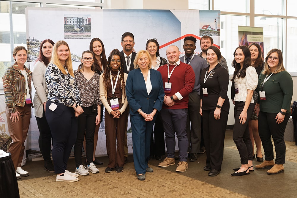 Governor Janet Mills posing and smiling with Husson students and faculty.