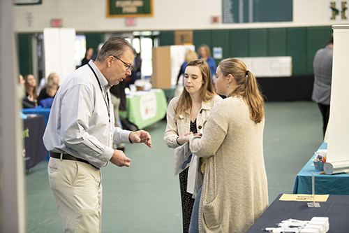 Husson University students are shown interacting with a business representative at the 2022 Career Fair.