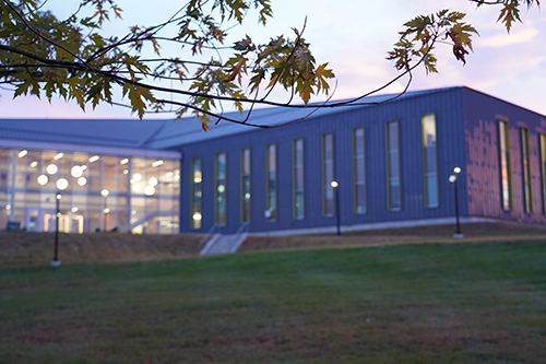 Alfond Hall is shown at dusk.
