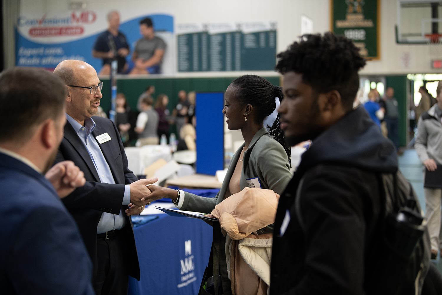 Students are shown interacting with an organization representative at the 2022 Fall Career Fair at Husson University.