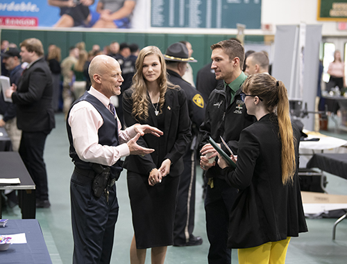Students speak with law enforcement professionals at Husson University during a career fair in 2022.
