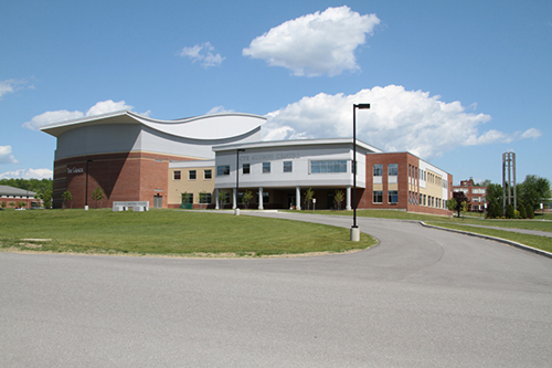 A brick building with a curved roof is shown in this photo of Beardley Meeting House on Husson University's campus.