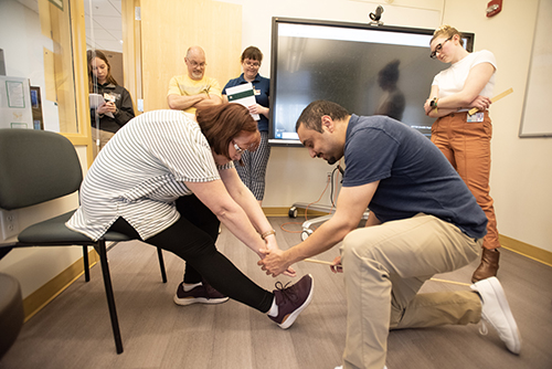 A patient is assisted by a Husson University physical therapy student in this photo.