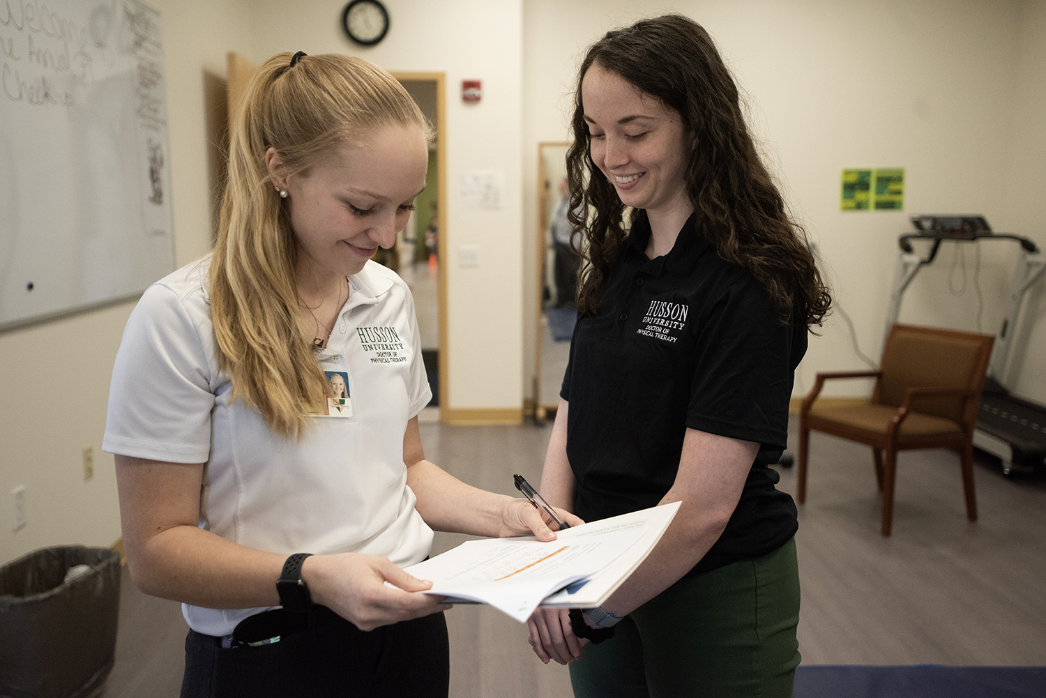 Two Husson University physical therapy students are shown interacting.