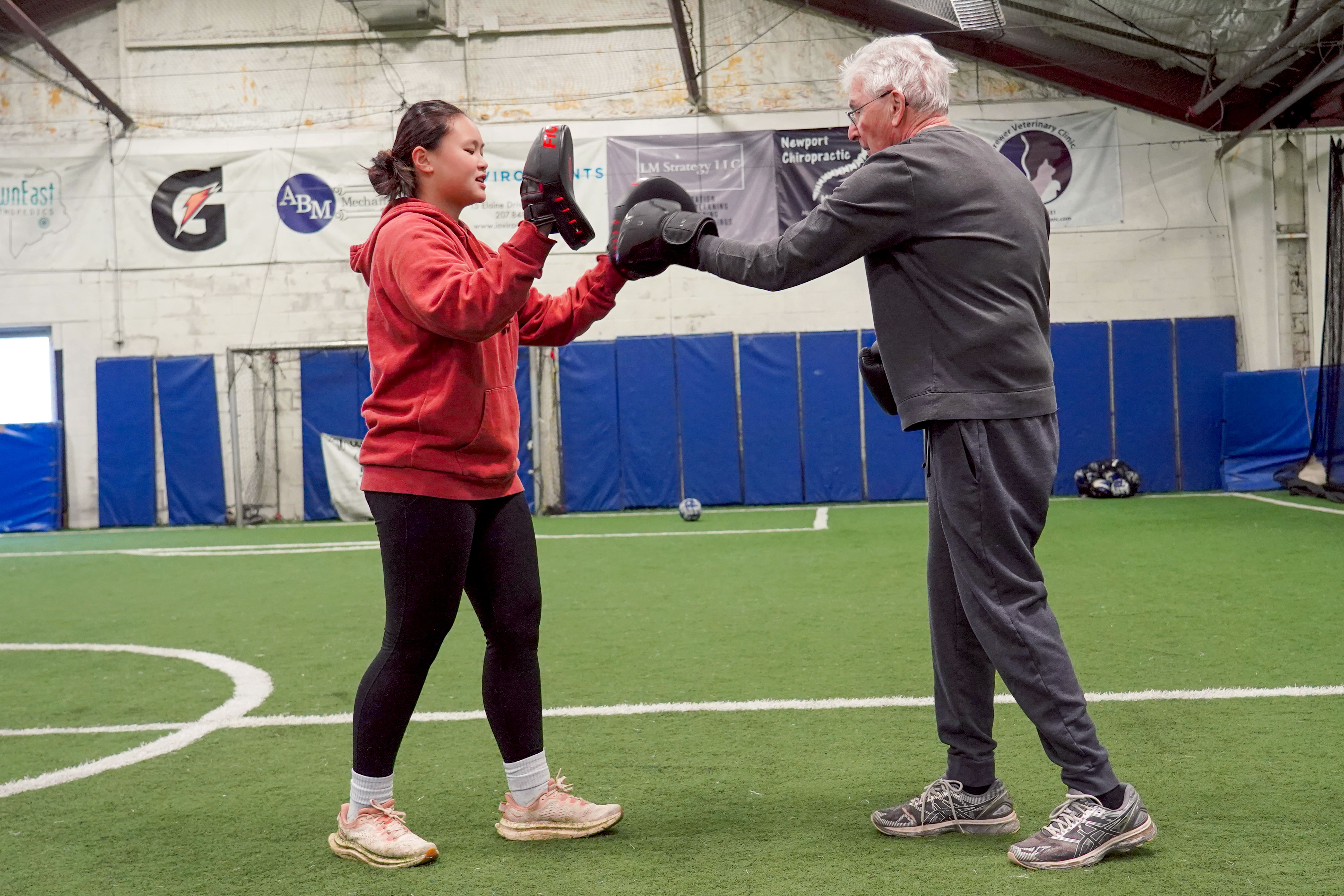 Husson student does boxing drill with individual.