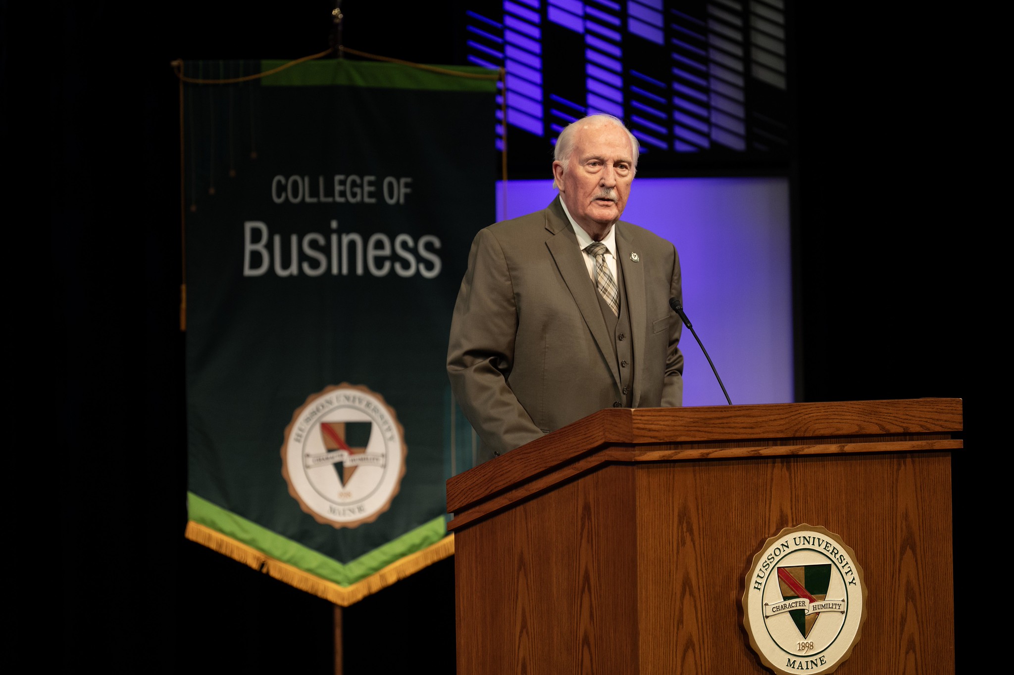 A man stands at a podium speaking.