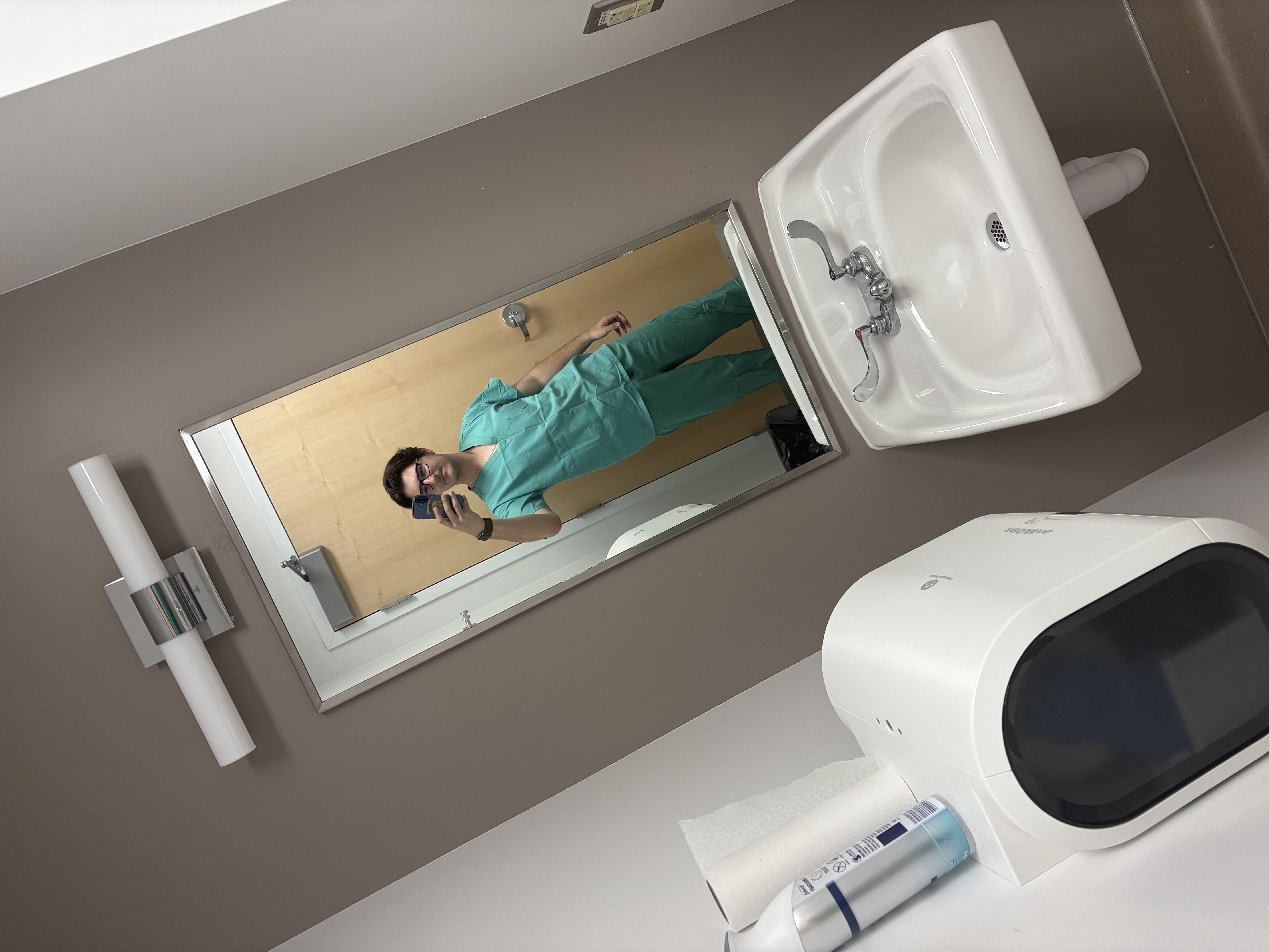 A man in blue scrubs is shown.