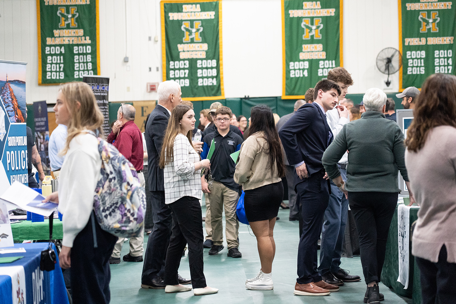 People are shown interacting and walking about at a career fair.