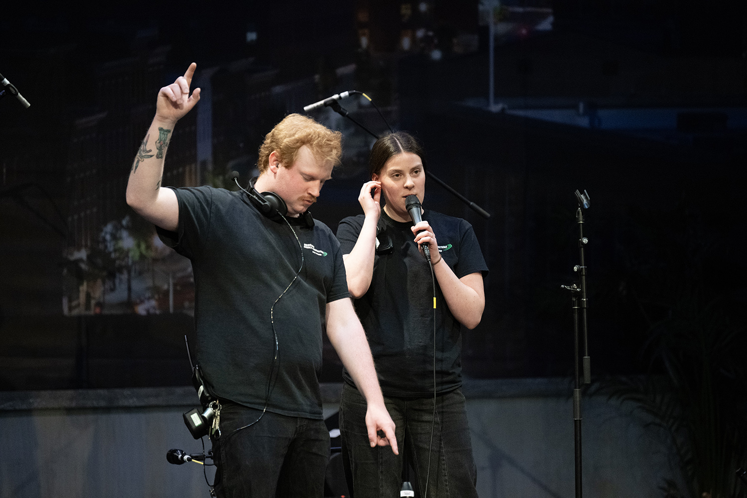 Two people perform a mic check.