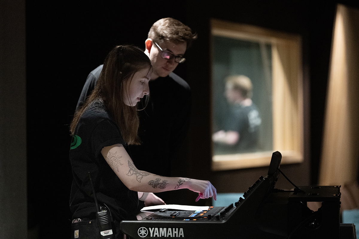 Young people work at an audio board.