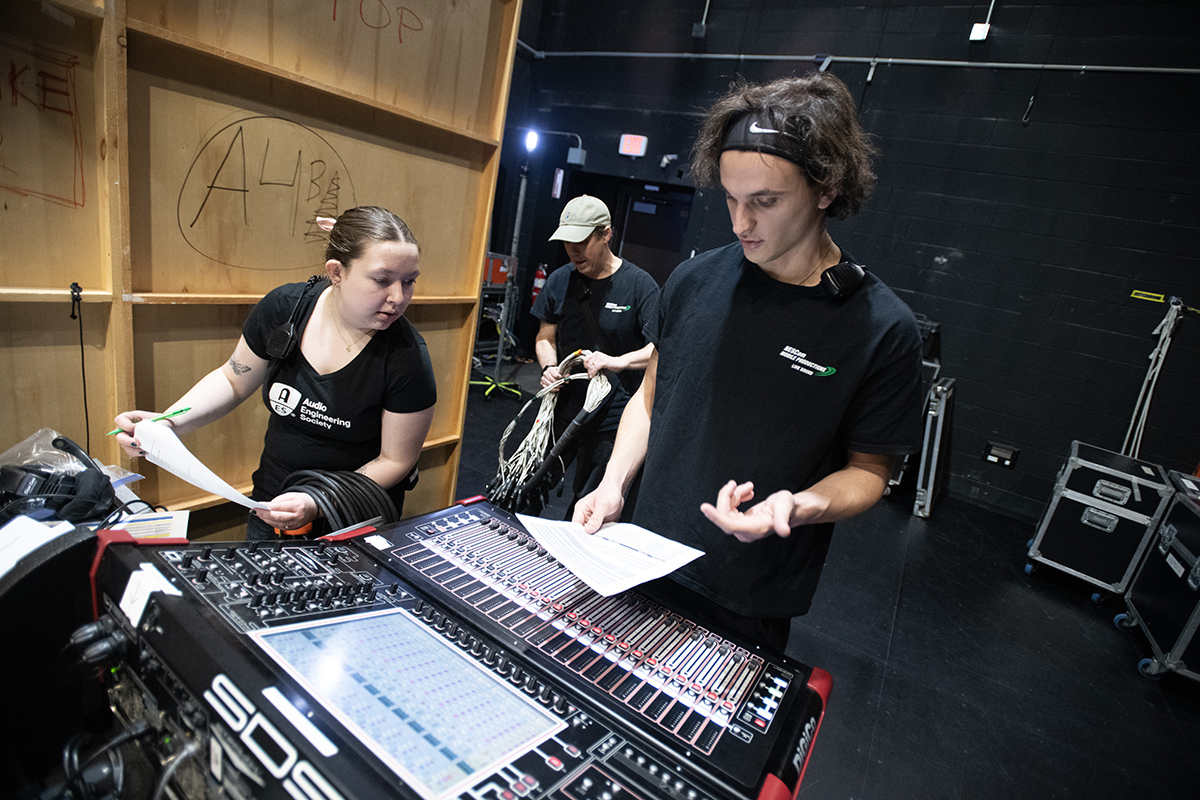 Young people work at an audio board.