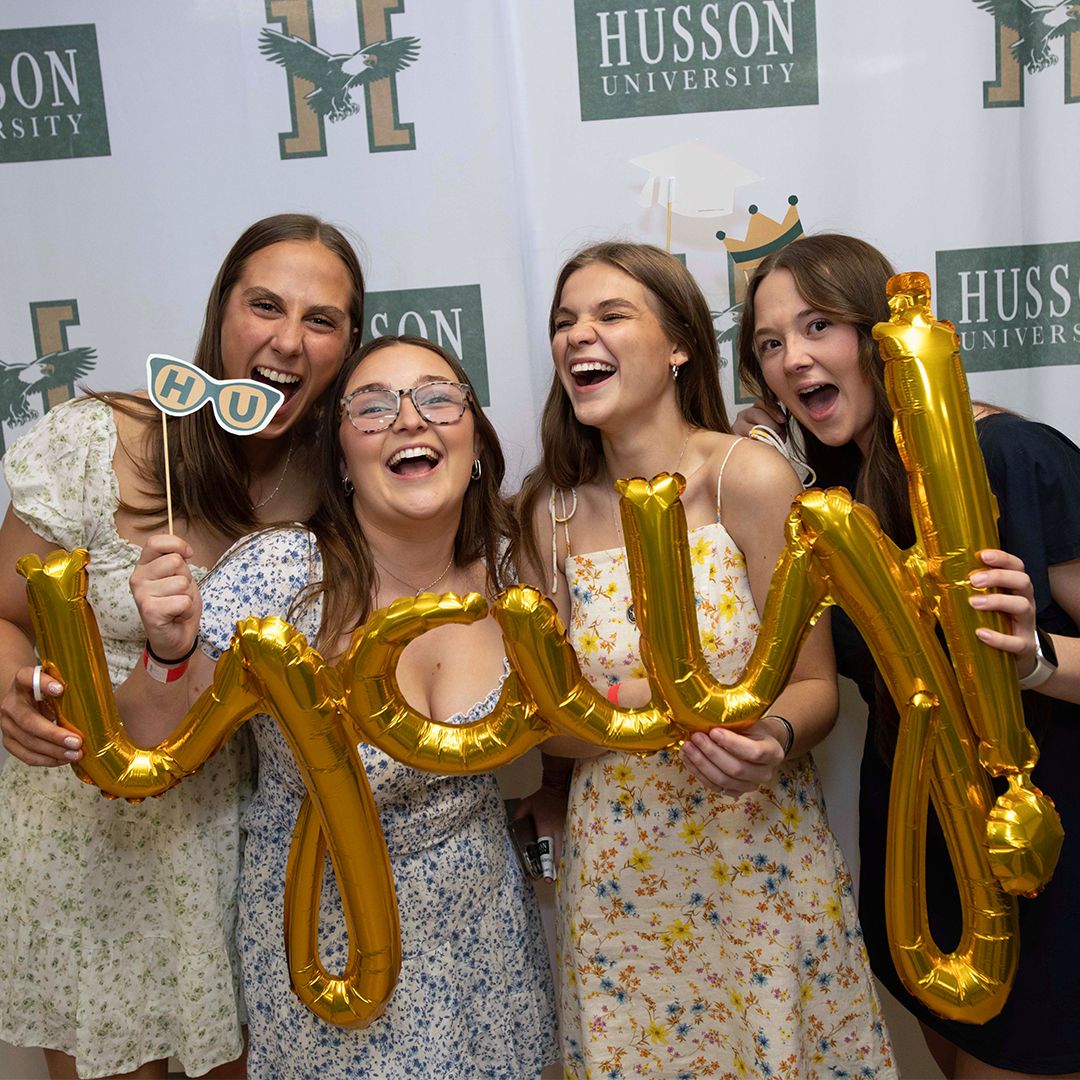 Four smiling young women pose for a photo.