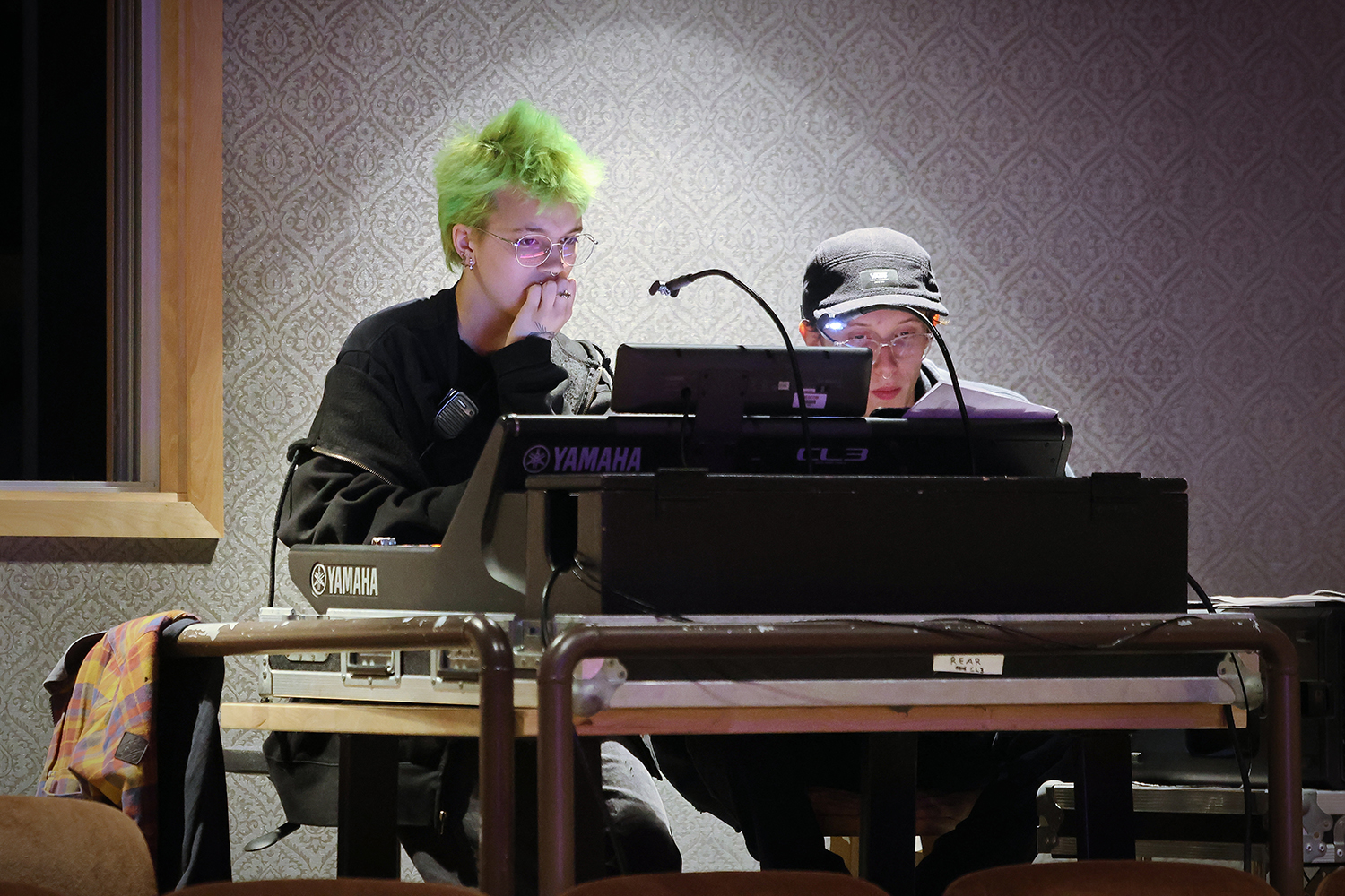 Two people operate a sound board.