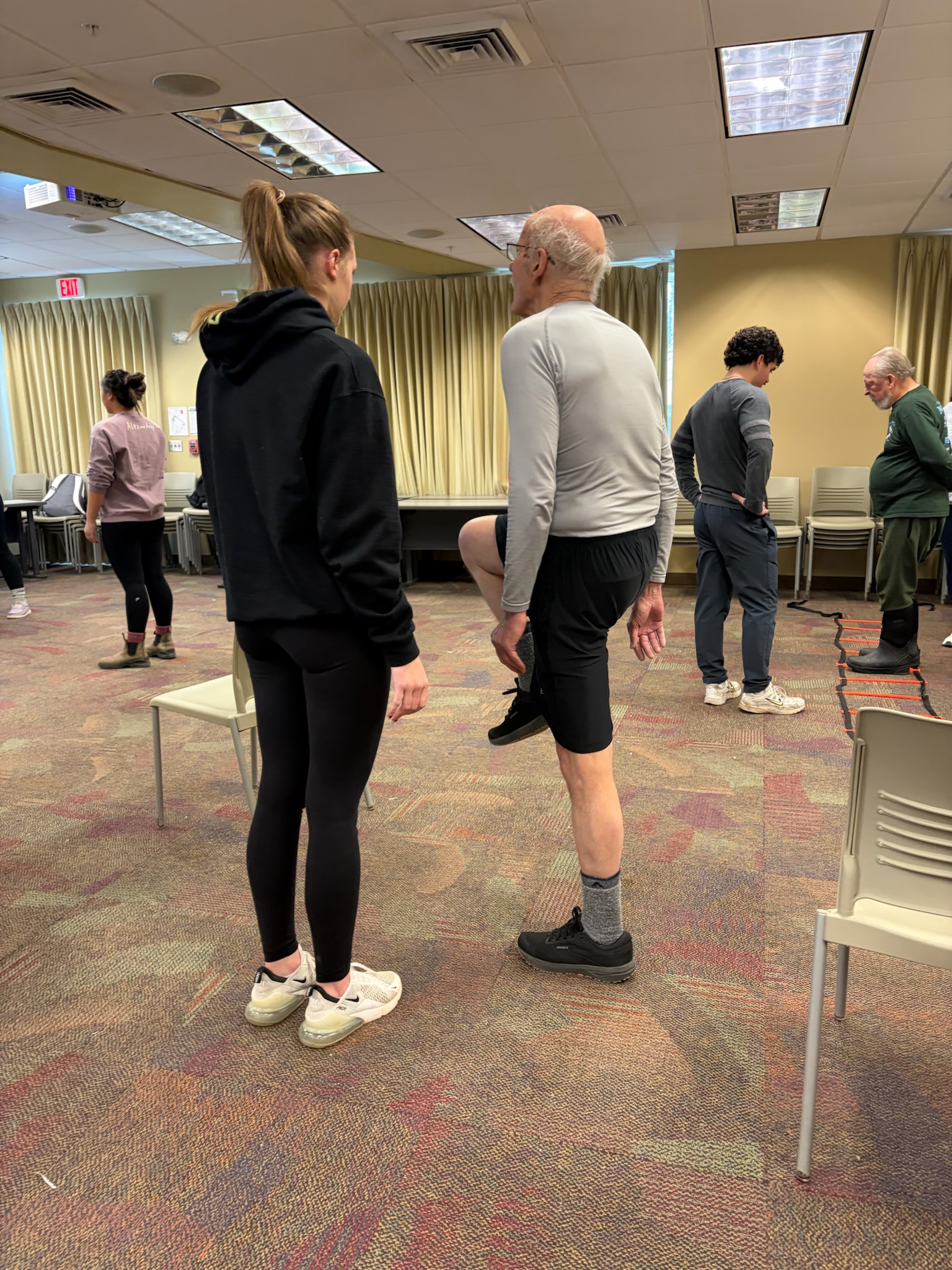 A trio of people work together on an exercise.