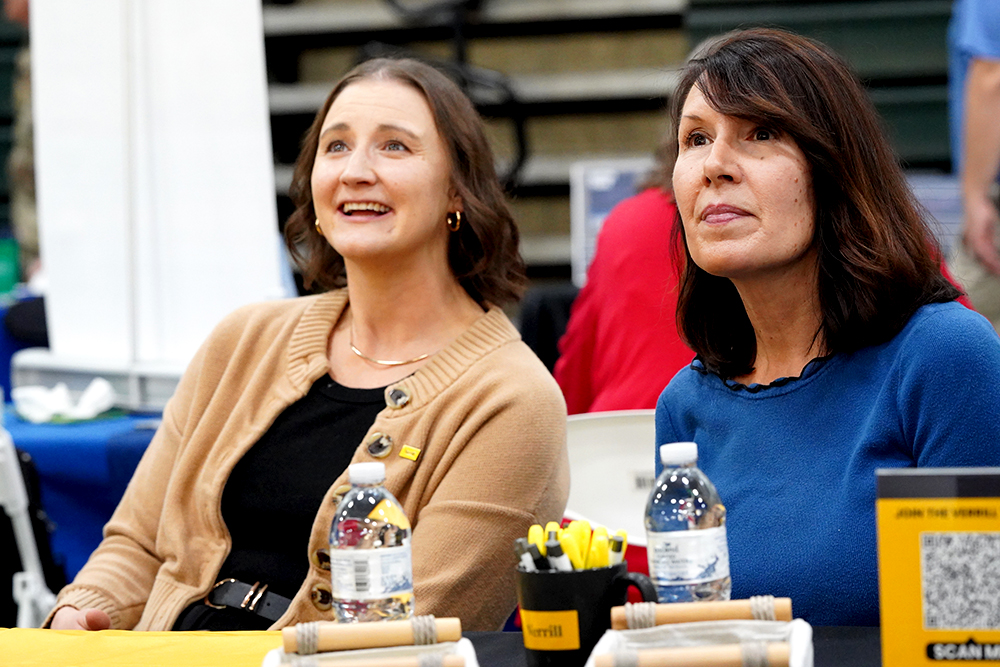 Two women look across a table.