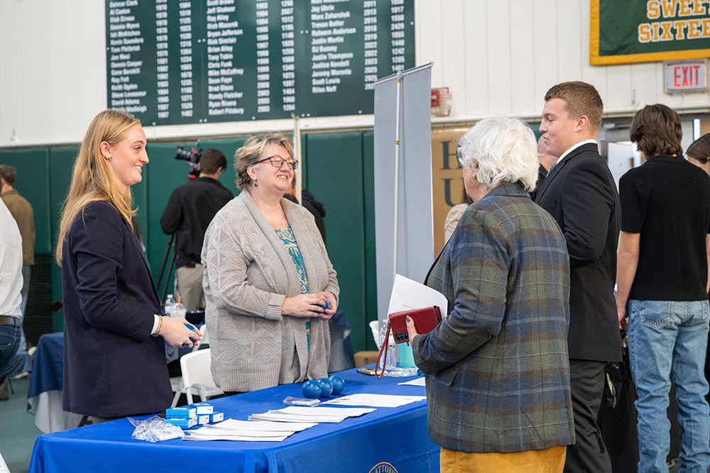 Two women speak animatedly with two other people.