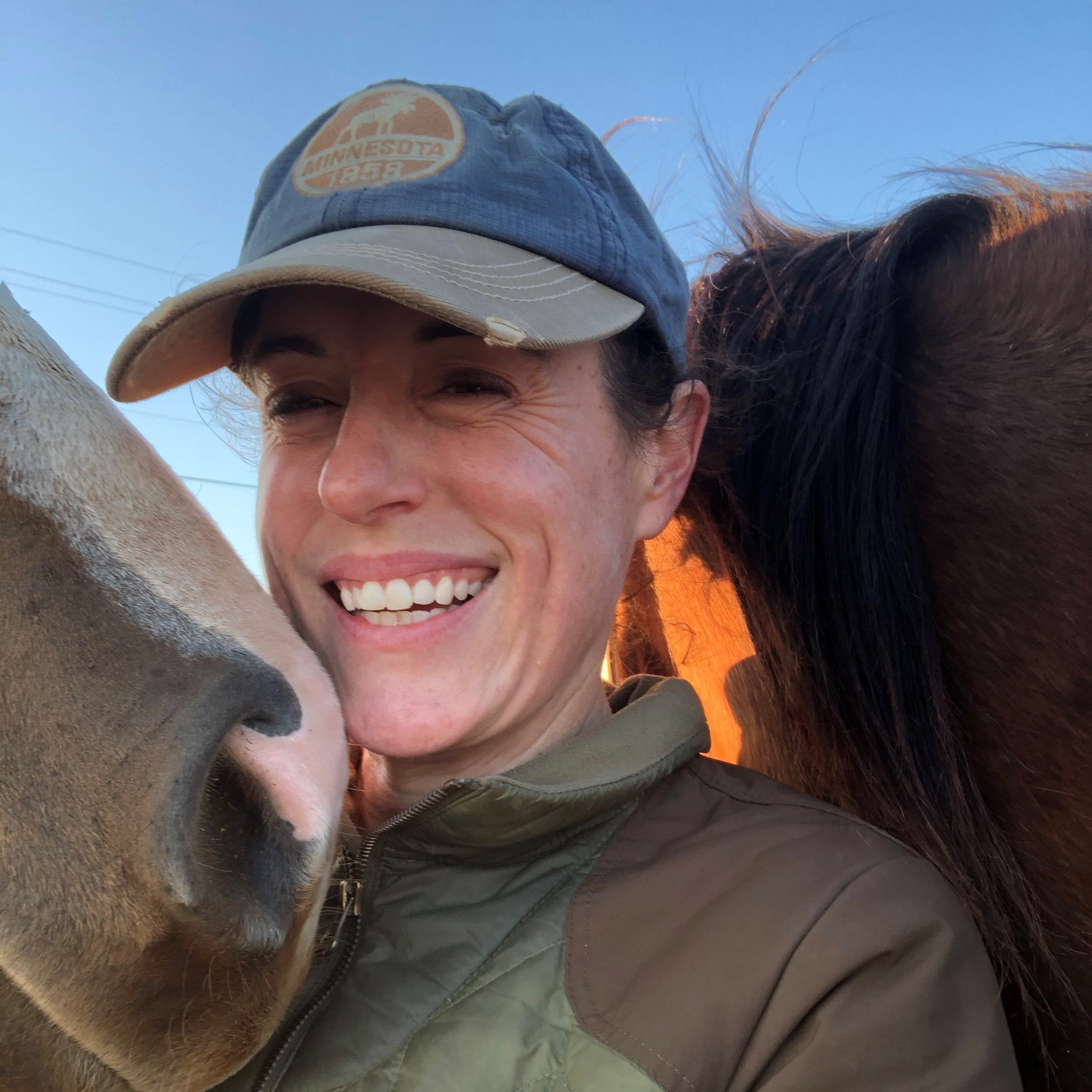 Emily Kieson standing next to a horse.