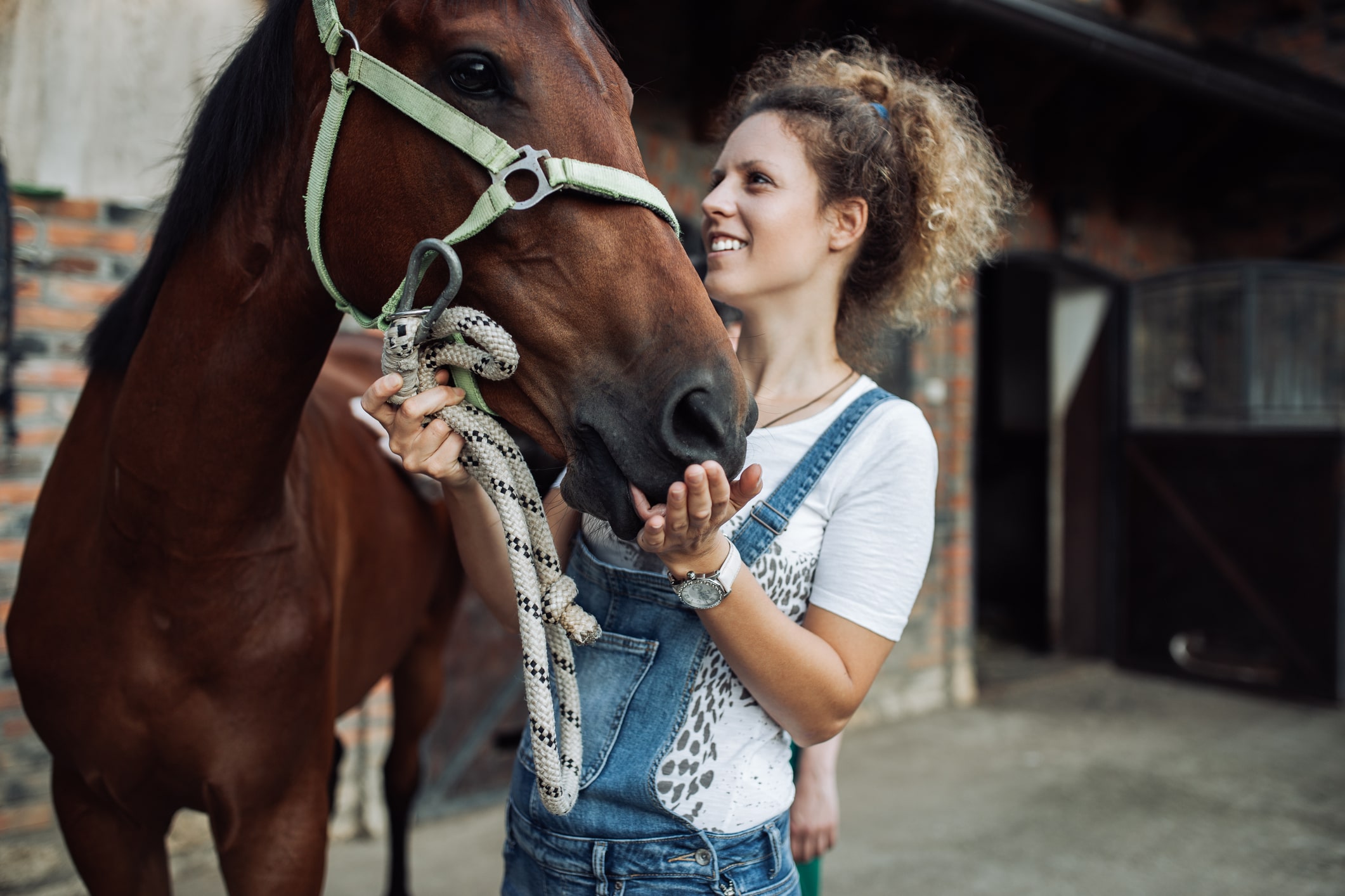 Woman standing next to a horse.