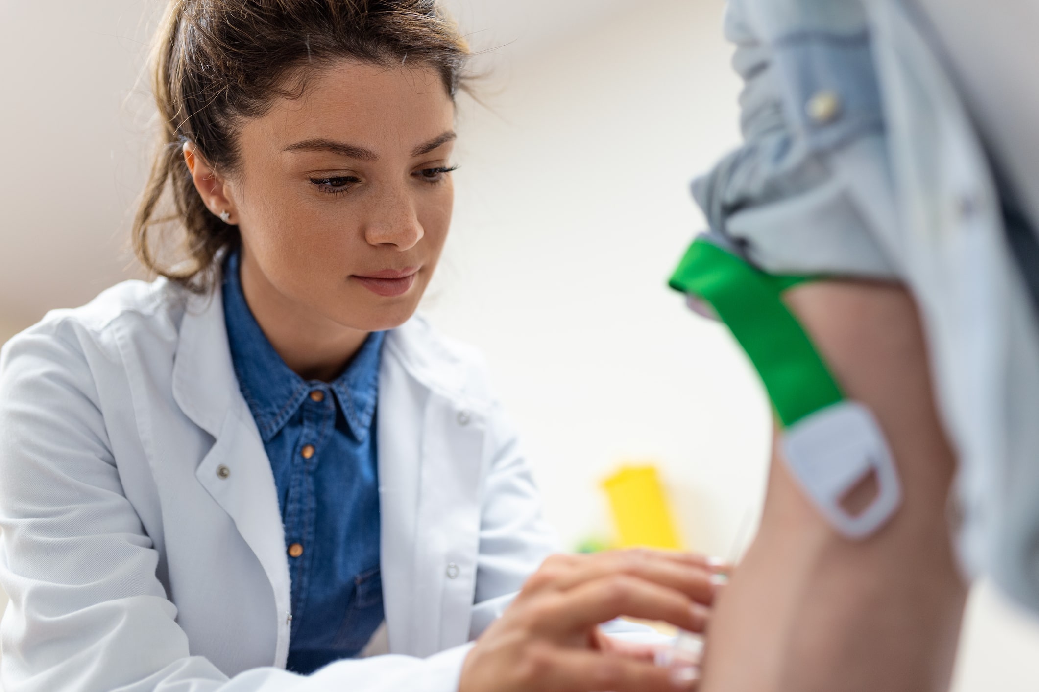 Female doctor performing a blood test on a patient.