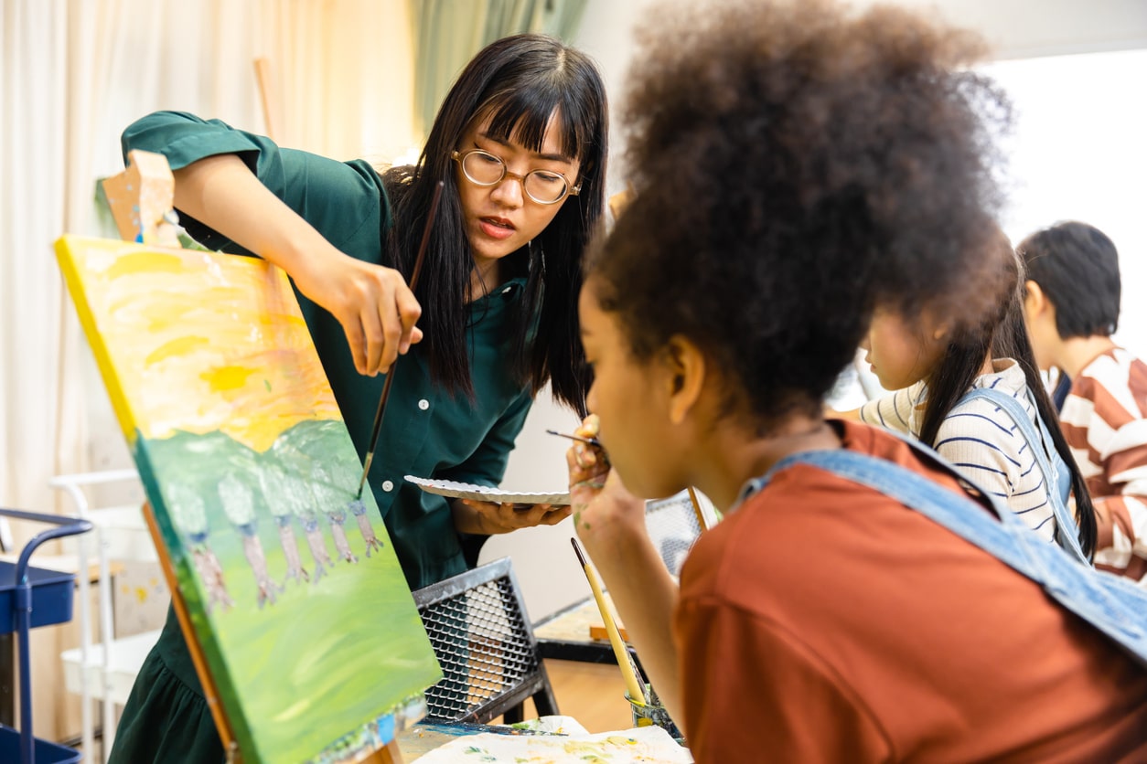 Art teacher showing students how to paint.