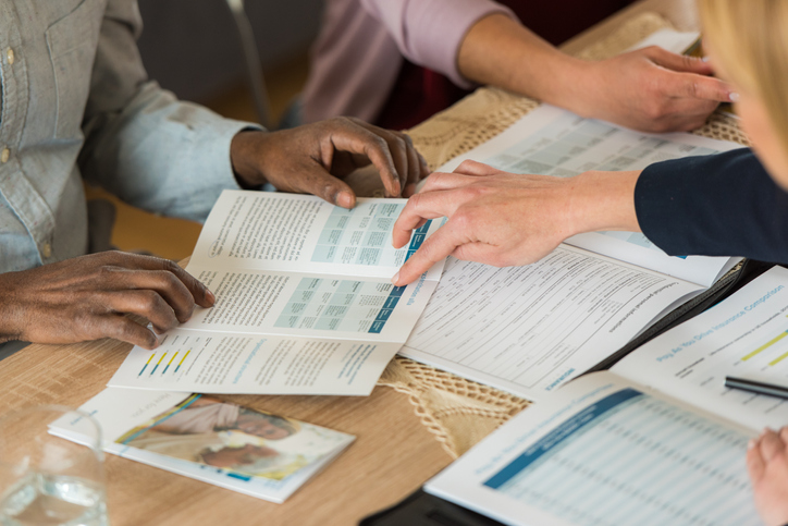 Financial planner showing customers a brochure.