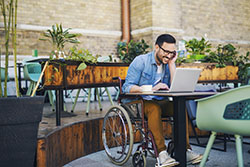 man in wheelchair working on laptop