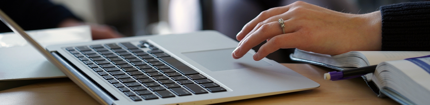 student typing on laptop