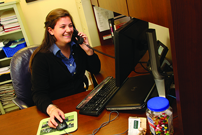 person talking on a phone while working at a computer