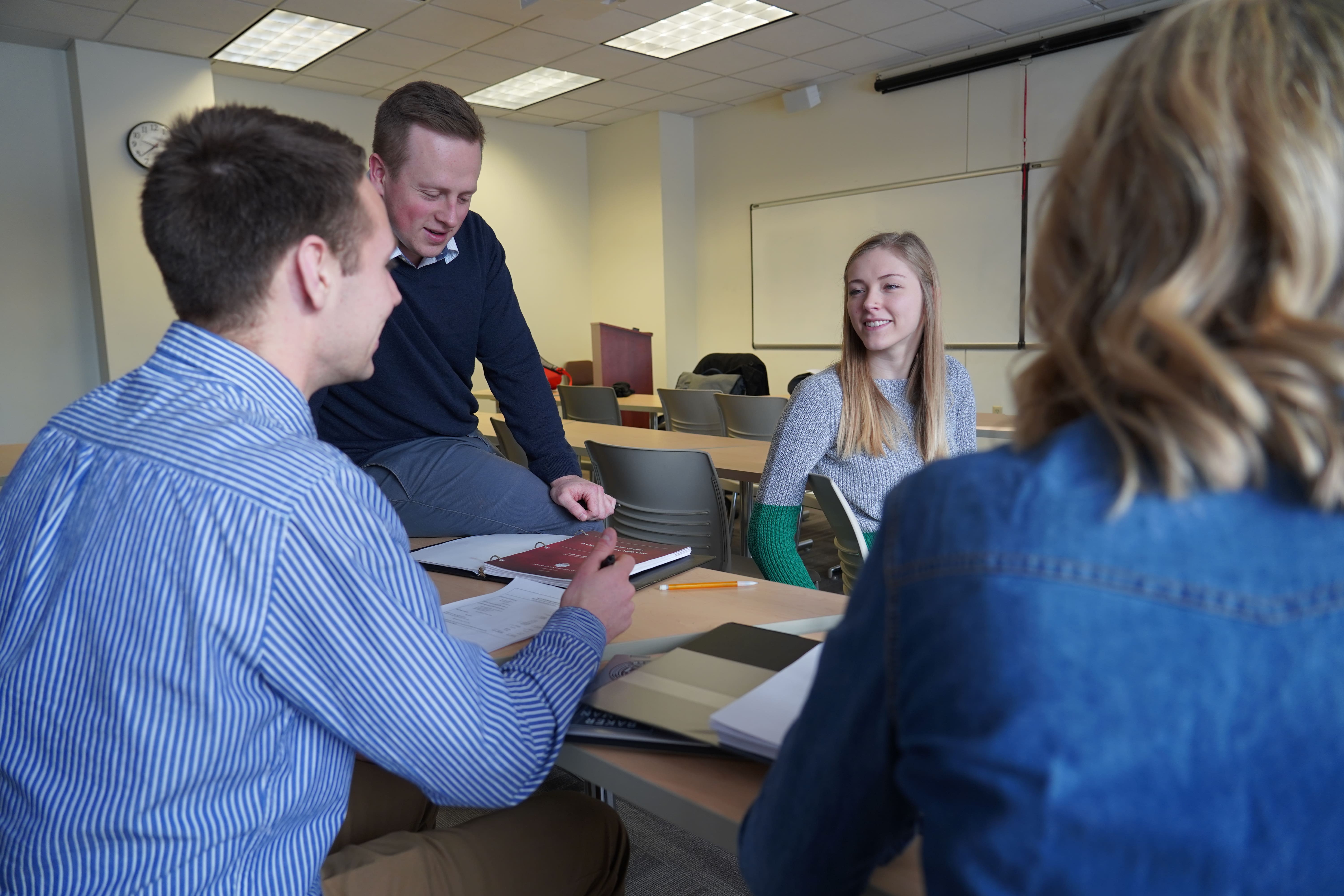 students talking to a teacher in a classroom