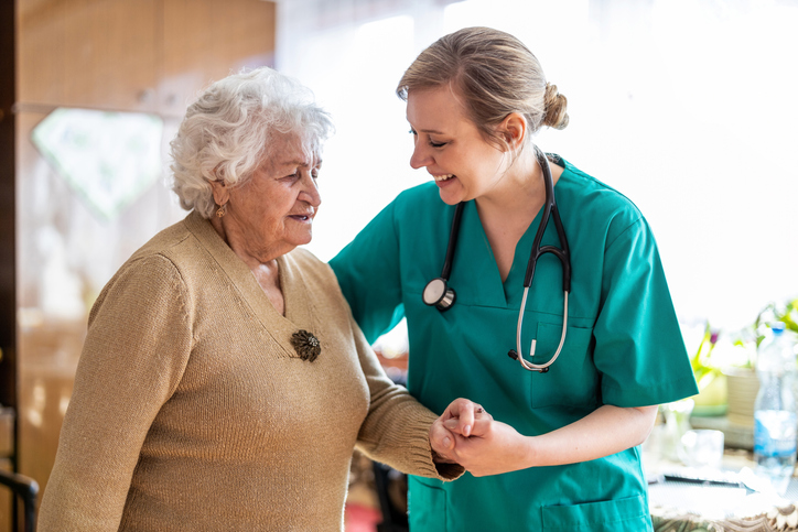 nurse holding an elderly woman's hand