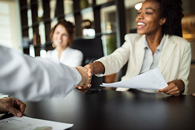 a woman shakes hands with someone at a table