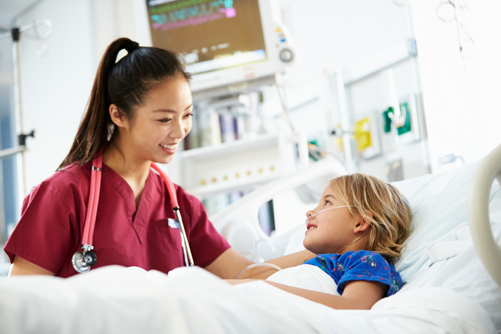 female nurse smiling and talking to a young patient