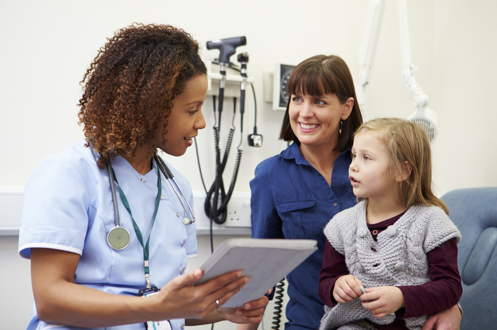 Appointment For Mother And Daughter With Nurse In Clinic Using Digital Tablet