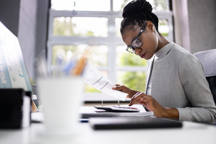 Woman using a calculator at her desk.