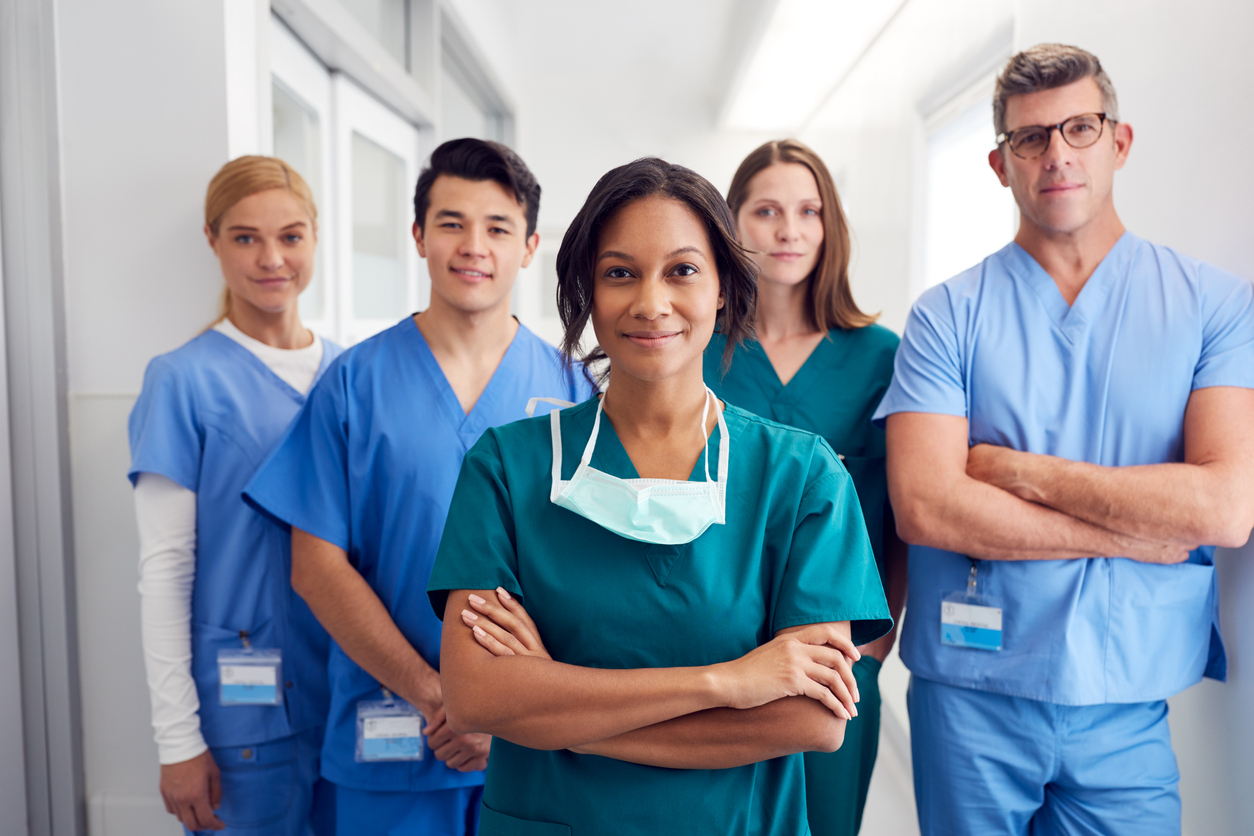 Group of five nurses standing next to eachother.