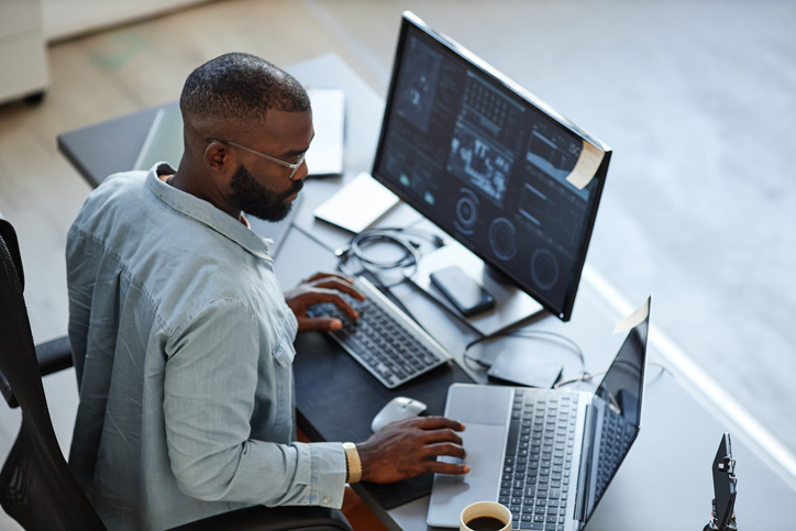 A male software developer works at his desk.