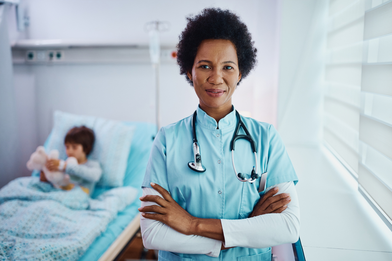 Nurse standing with her arms crossed while looking at camera.