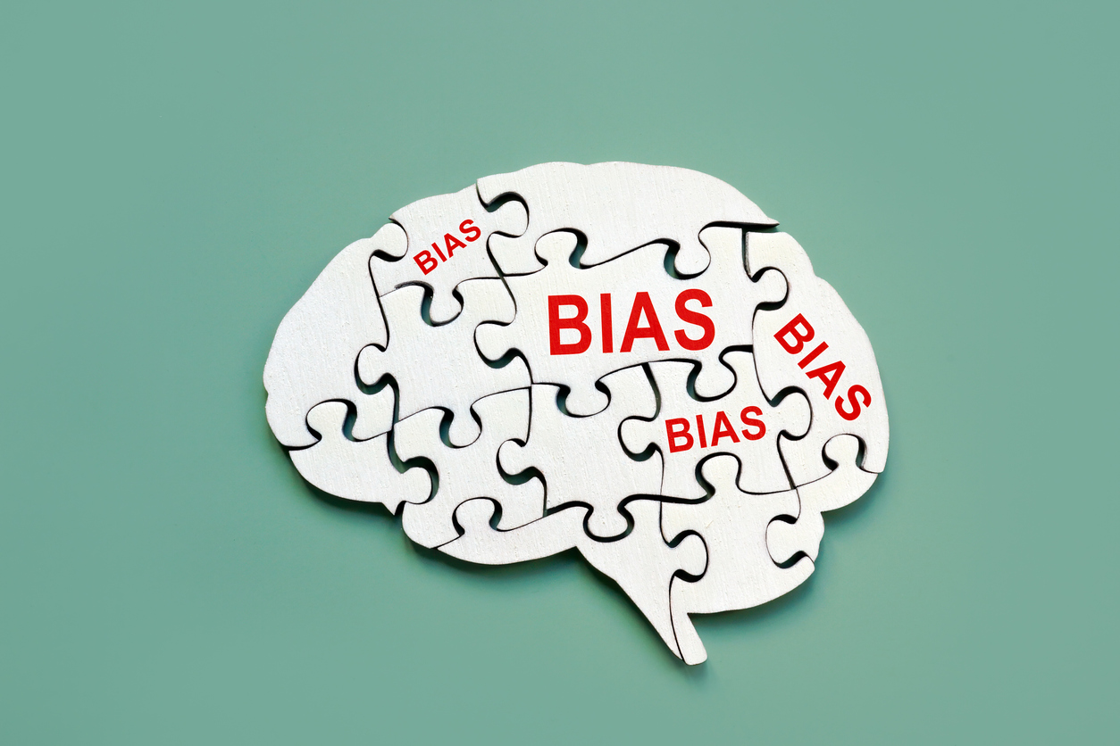 Illustration of a brain made of puzzle pieces with the word "bias" on them.