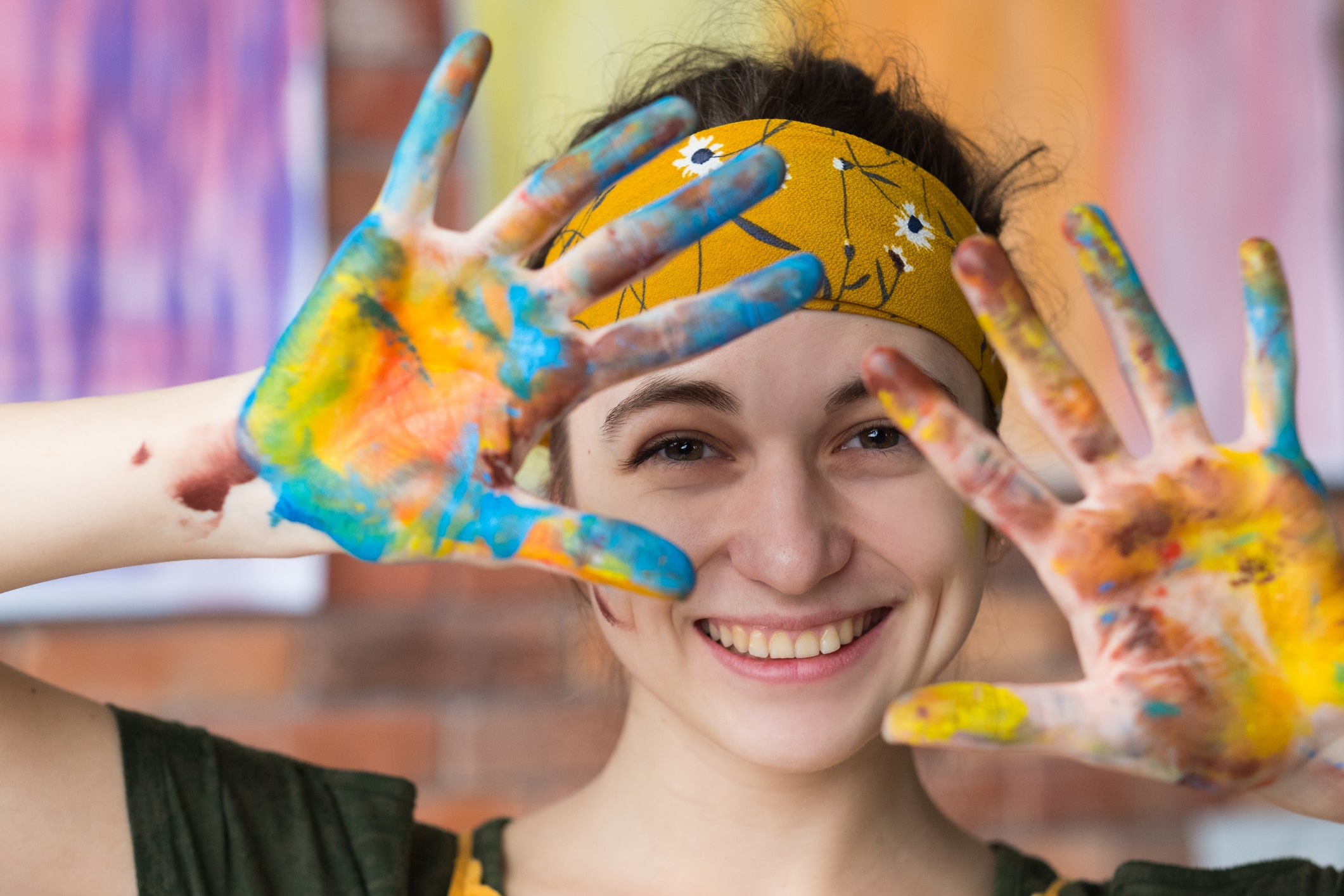 Girl showing her hands covered in paint.