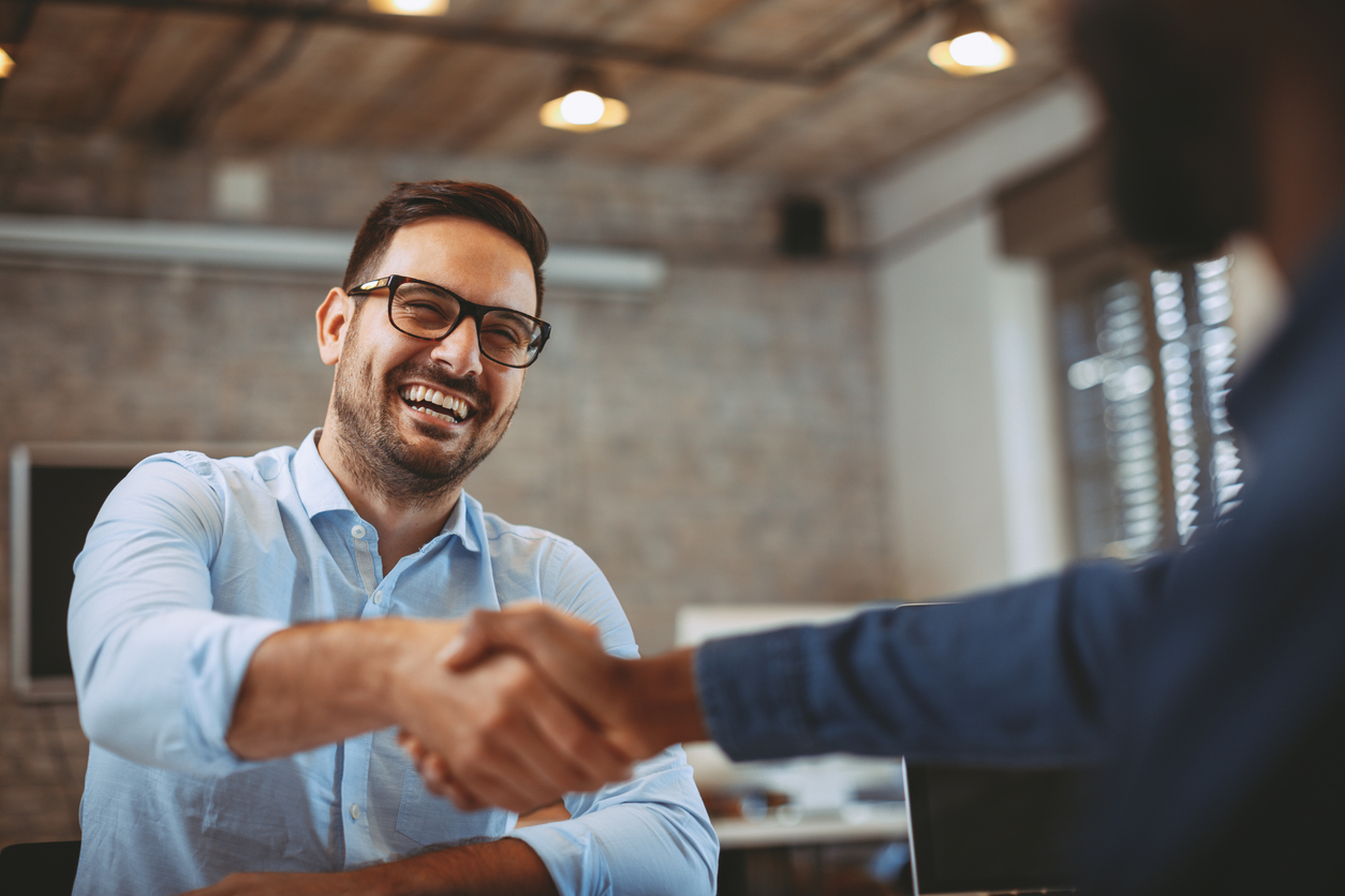 Man shaking someone's hand while in an interview.