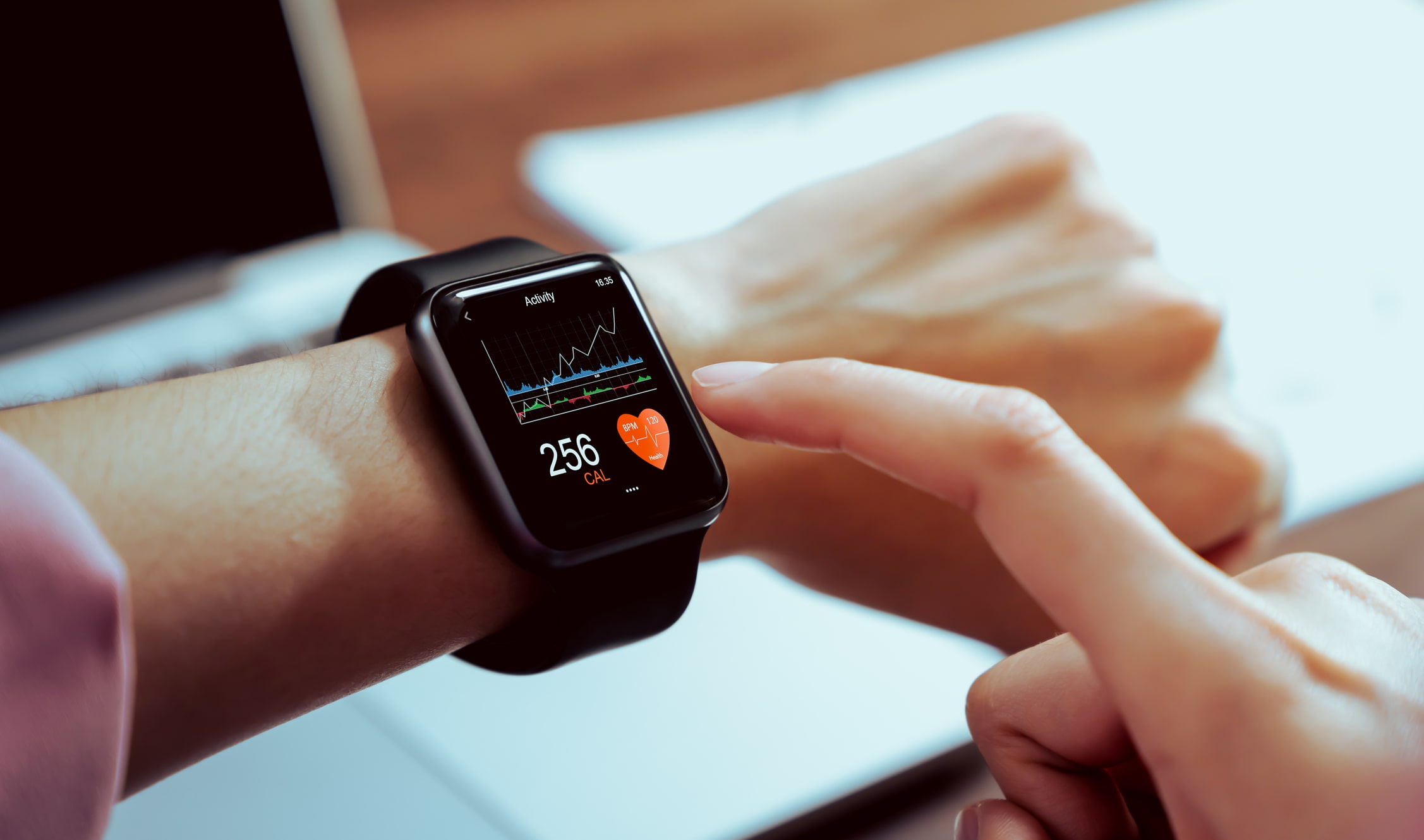 Close up of hand touching a smartwatch with a health app on the screen.