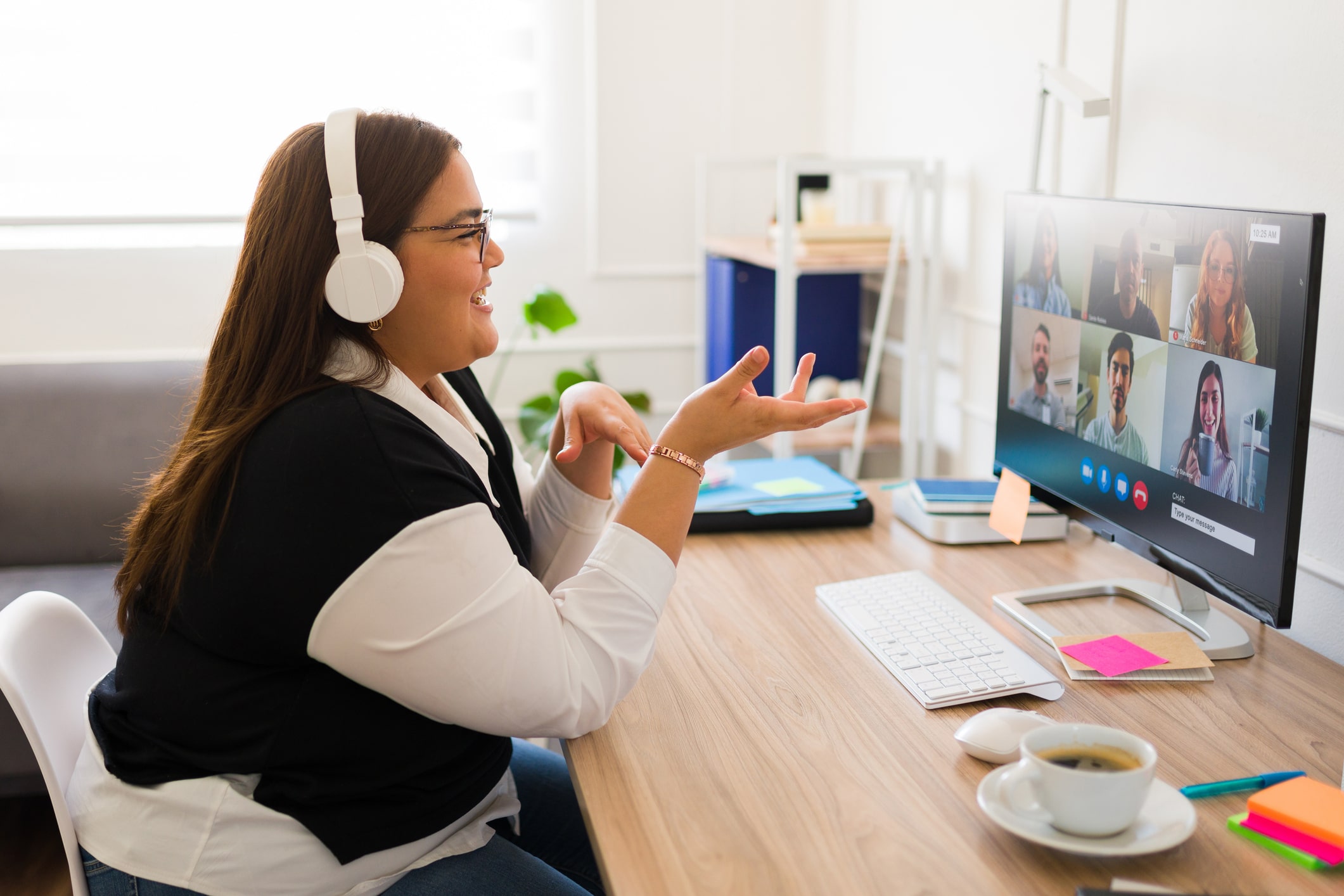 Woman talking to multiple people during a video call on her computer.