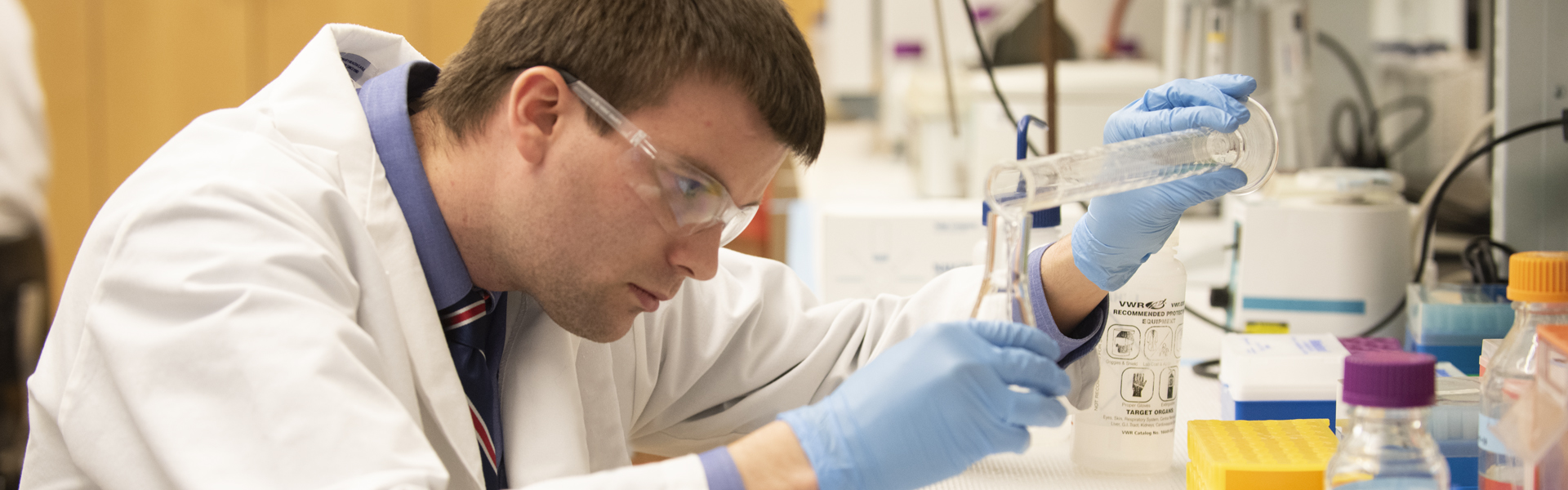 A pharmacy student prepares medication in a simulated la